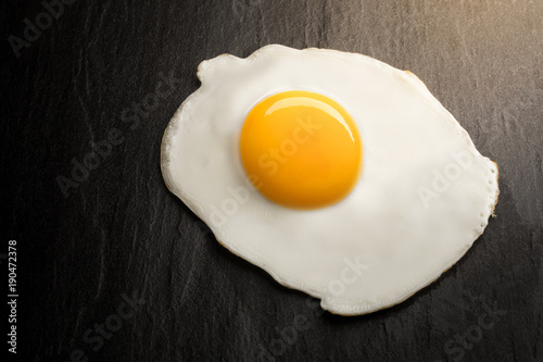 close up fried egg on black background