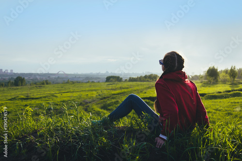 Girl posing  where a lot of grass in the field.