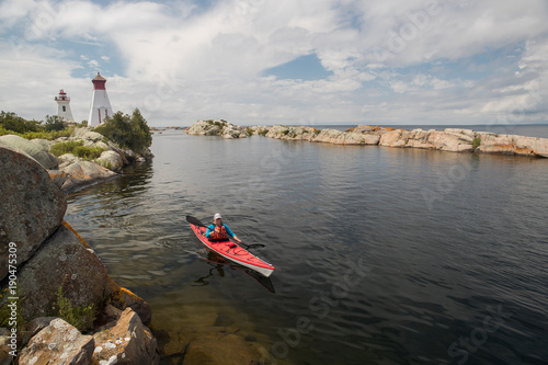 Obraz na płótnie Active senior paddling a sea kayak on Georgian Bay, Ontario, Canada. w salonie