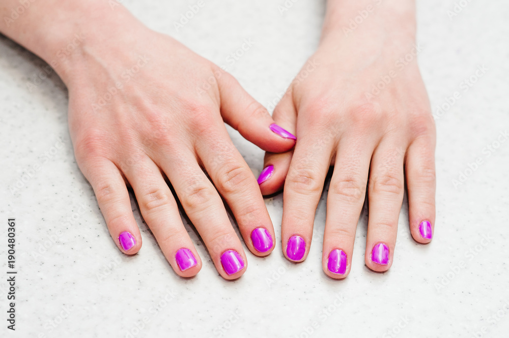 Hands on the table with manicure..Nails purple, pink. Hands on the table with manicure..Nails purple, pink.