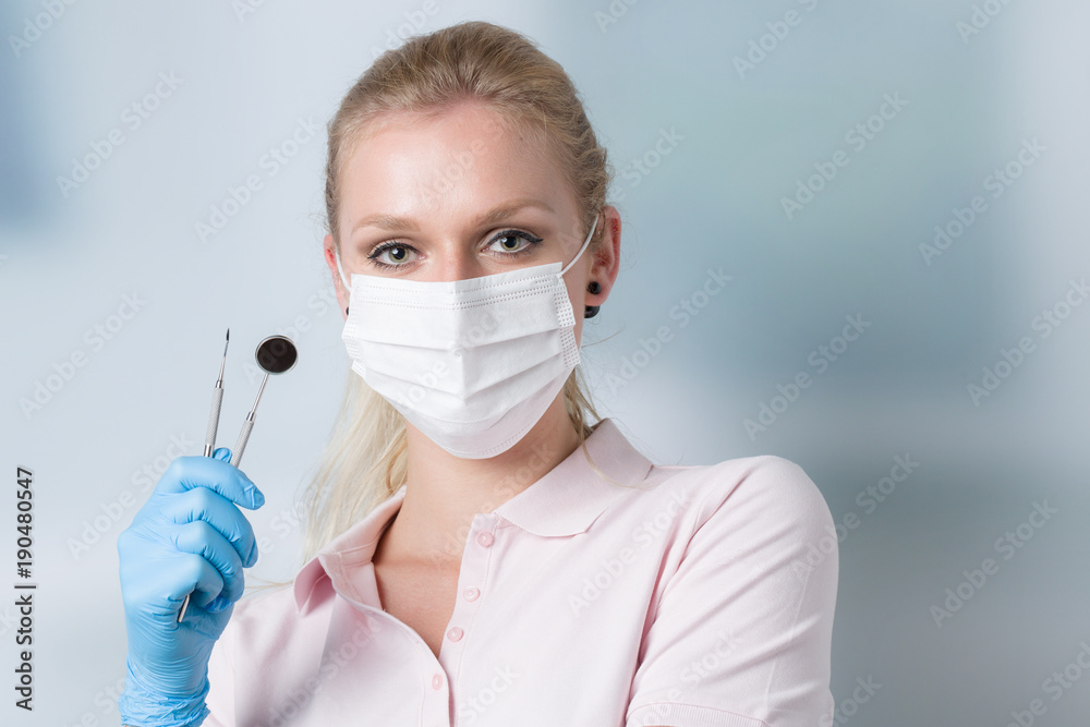 hübsche Zahnärztin mit Zahnhaken und Zahnspiegel für die Zahnreinigung hübsche Zahnärztin mit Zahnhaken und Zahnspiegel für die Zahnreinigung