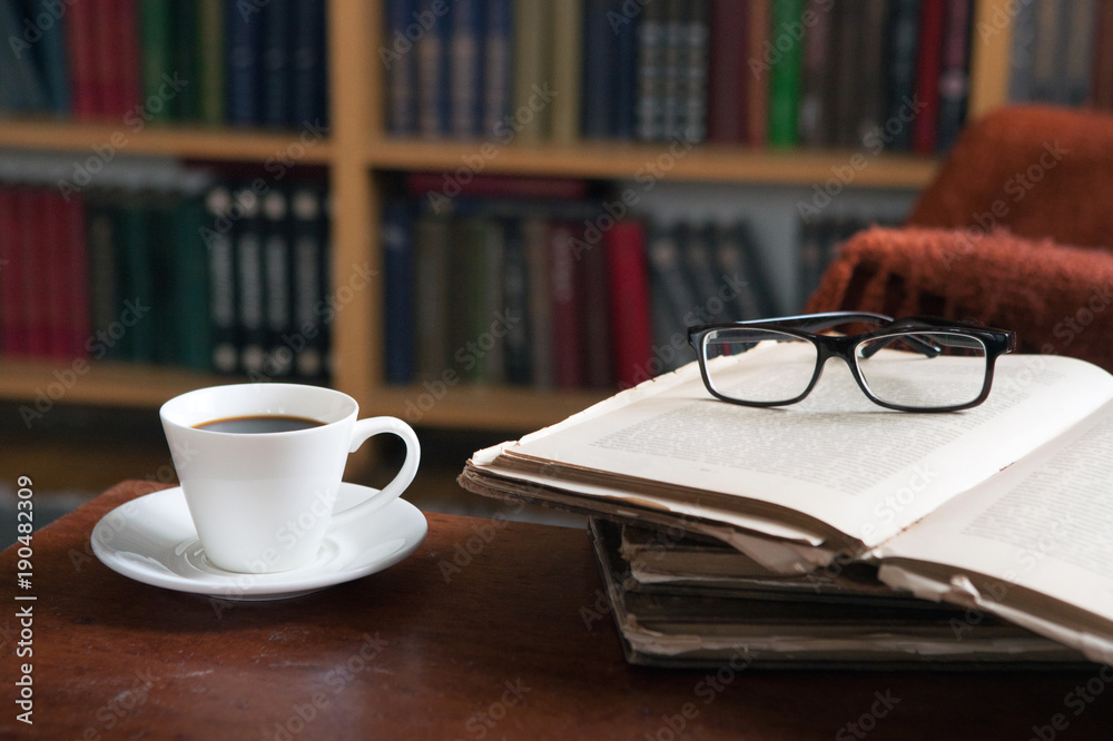 Sweet moments of relaxation with books and a cup of coffee. Vintage books, glasses, chair, library