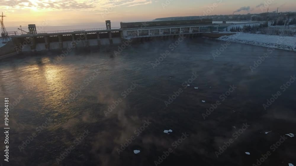 custom made wallpaper toronto digitalFly over soaring ice water and approaching the building of a power station. Novosibirsk reservoir and hydroelectric power station: frozen water and sun, reflected in the ice crust. Aerial view.