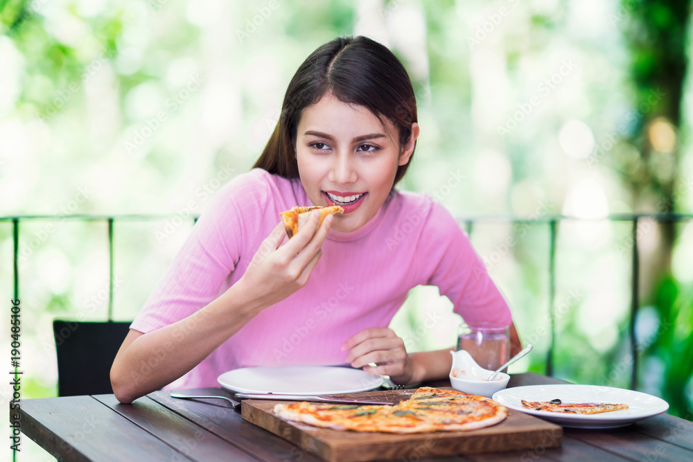Asian lady eating pizza