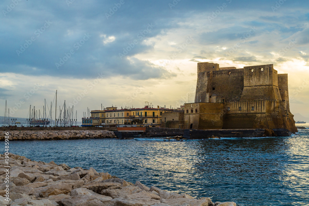 Egg Castle (Castel dell'Ovo) at the sunset. A seaside castle in Naples, located on the former island of Megaride, now a peninsula, on the Gulf of Naples in Italy.