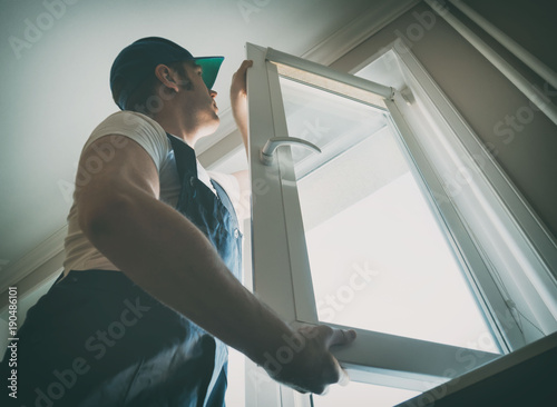 Professional handyman installing window at home. photo