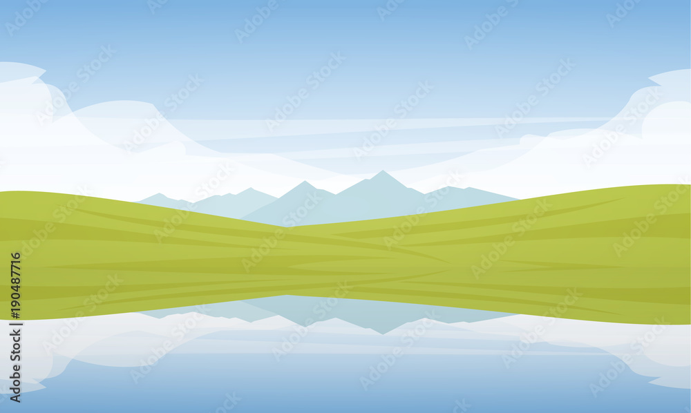 Obraz premium Mountain Lake landscape with green fields and reflection.