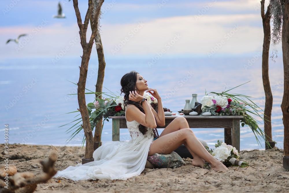 beautiful girl sitting near the sea. style of Boho beautiful girl sitting near the sea. style of Boho