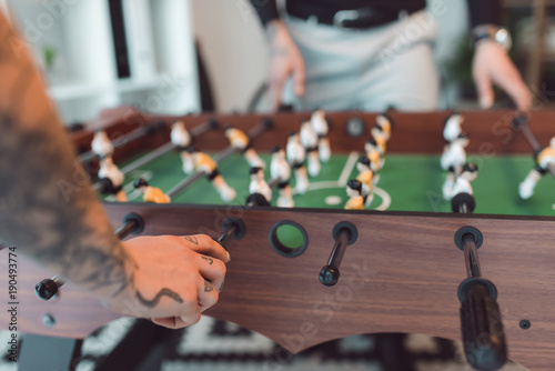 selective focus of colleagues playing table football in office