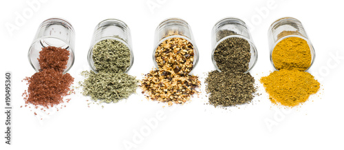 glass jars with various spices on white background