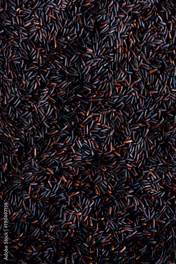 Raw dark red, balck purple rice, texture. Riceberry pattern background. Food ingredient background. Top view, healthy lifestyle concept.