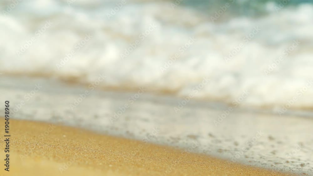 Texture of water and sand. Coast. Bright golden sand. Small waves break on the sandy shore. Sea swell Texture of water and sand. Coast. Bright golden sand. Small waves break on the sandy shore. Sea swell