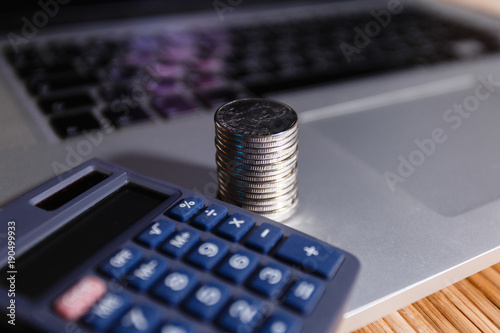Wallpaper Mural Silver coins stack with a calculator on grey notebook. Business, finance, saving money or car loan concept : coins stack, calculator and laptop Torontodigital.ca