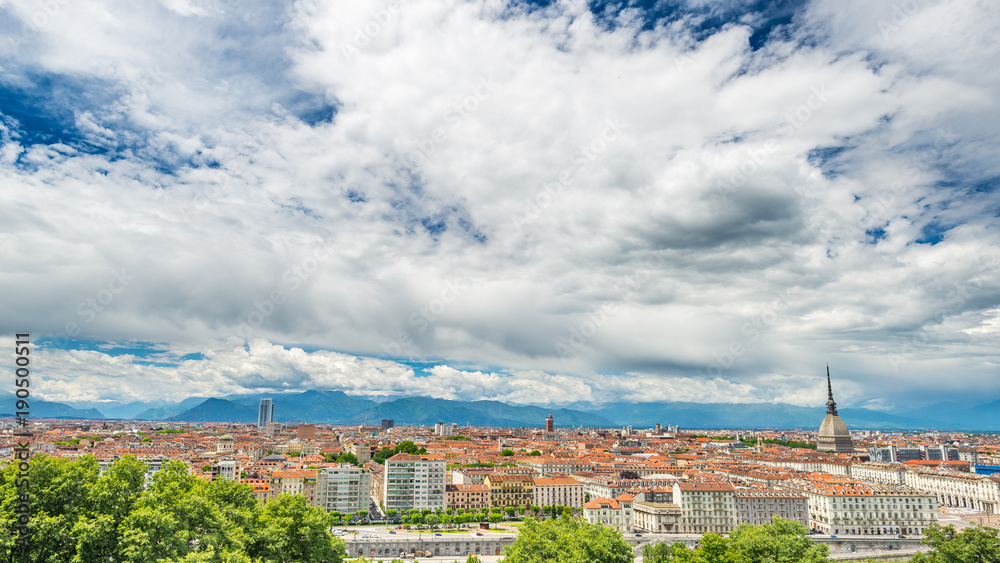 Turin Cityscape, Italy, Torino skyline, the Mole Antonelliana towering over the buildings. Wind storm clouds over the Alps in the background.