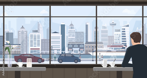 Man relaxing at the cafe and looking at the window