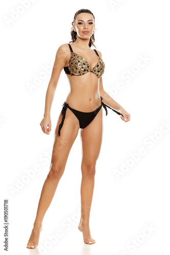 Beautiful fashion model in black bikini on white background