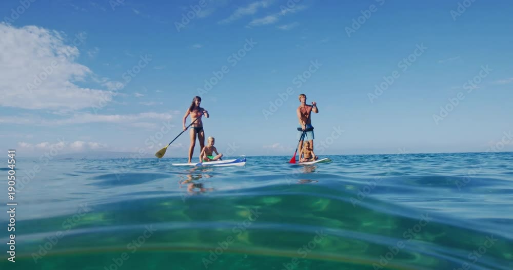 Family stand up paddle boarding in the ocean, active lifestyle