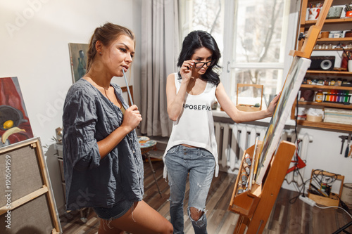 two girls in an artist studio. paints model photo