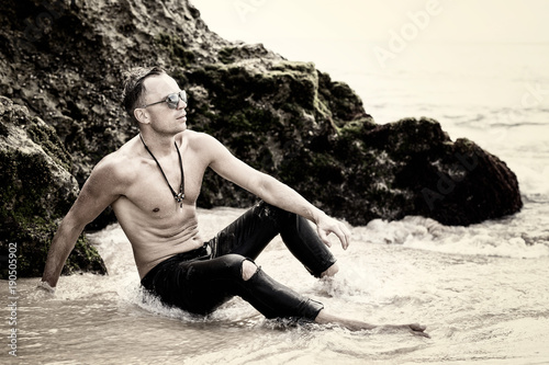 Man in wet jeans sitting in water