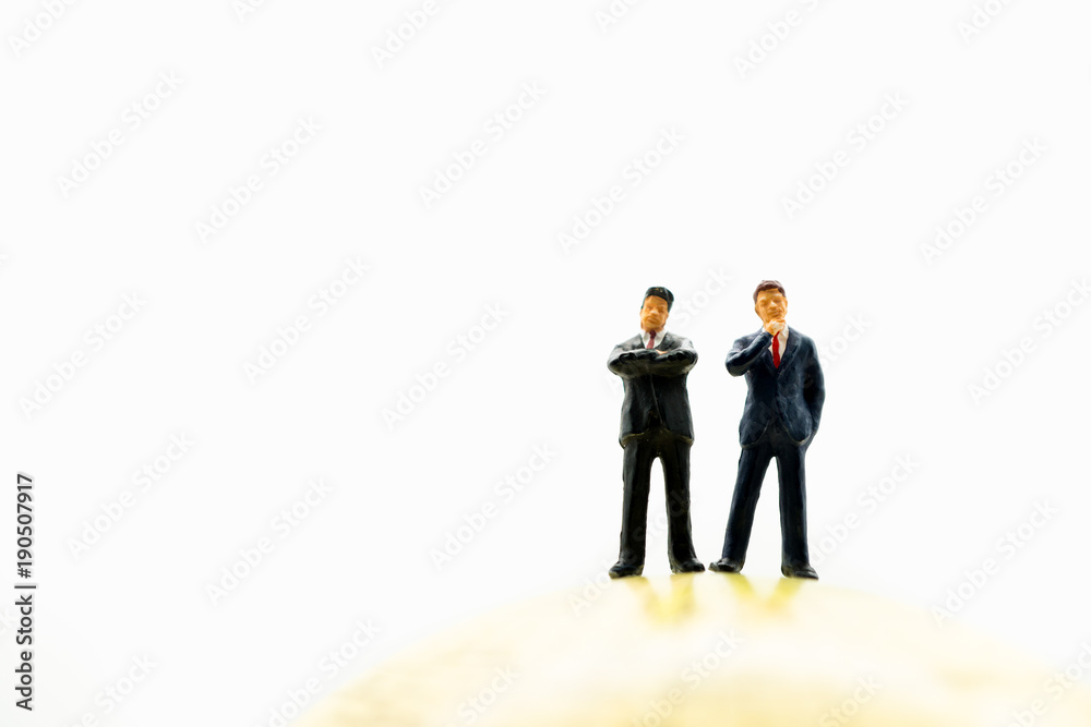 Miniature people, couple businessman standing on earth using as business management and teamwork concept Miniature people, couple businessman standing on earth using as business management and teamwork concept