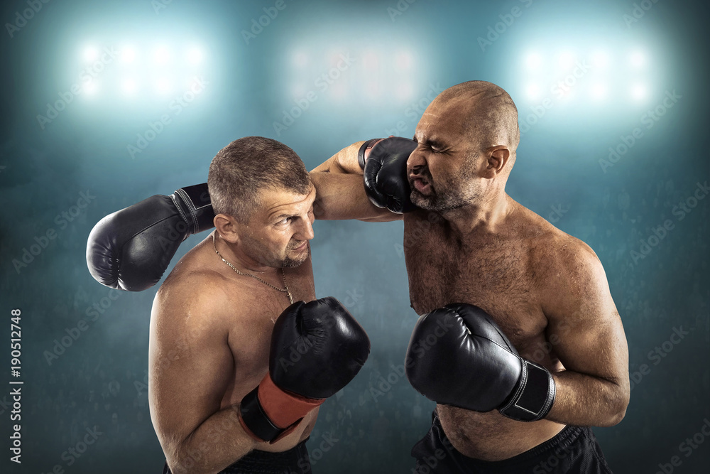 Two professional boxers, athletes in dynamic boxing action on th