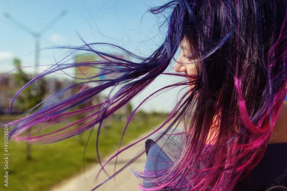 Colored blue and pink hair girl in the wind back view