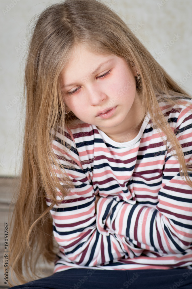 Little girl has a stomachache, holding her tummy and looking sick Little girl has a stomachache, holding her tummy and looking sick