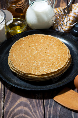 traditional thin pancakes in a frying pan, vertical