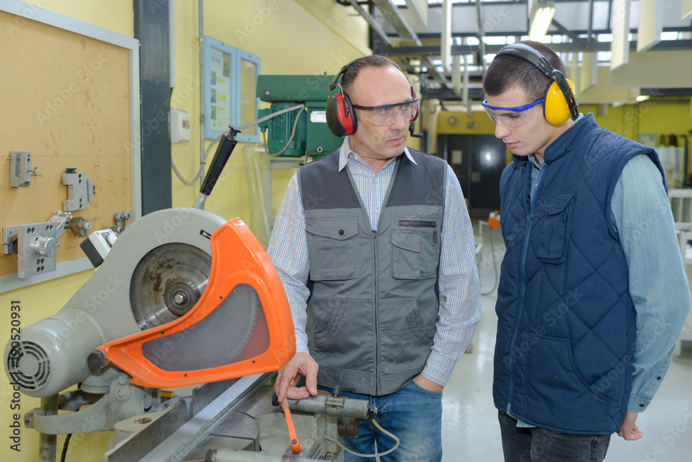 student and teacher in carpentry class using circular saw