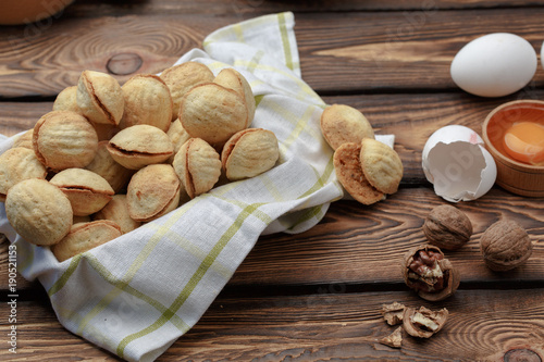 delicious walnut shaped shortbread sandwich cookies filled with sweet condensed milk and chopped pistachio nuts. against the background of the ingredients, view from above, close-up