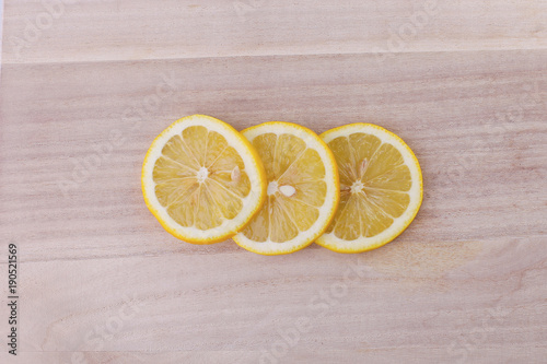 Top view of sliced lemon on wooden background.