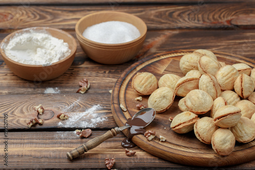 homemade cookies, nuts with condensed milk on wooden background. rural style
