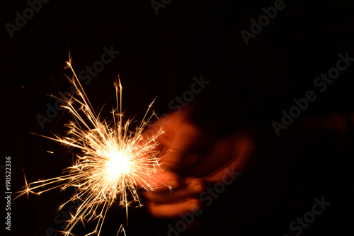 Blank background with bengal fire .Sparkler . New year party sparkler on black background A man holds a burning Bengal flame in his hands