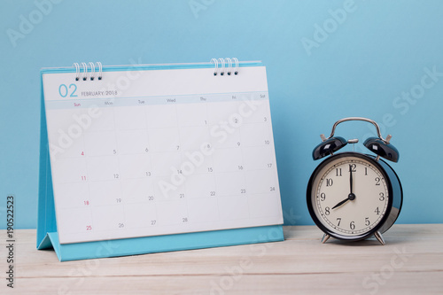 Vintage clock and calendar February on wood, time concept