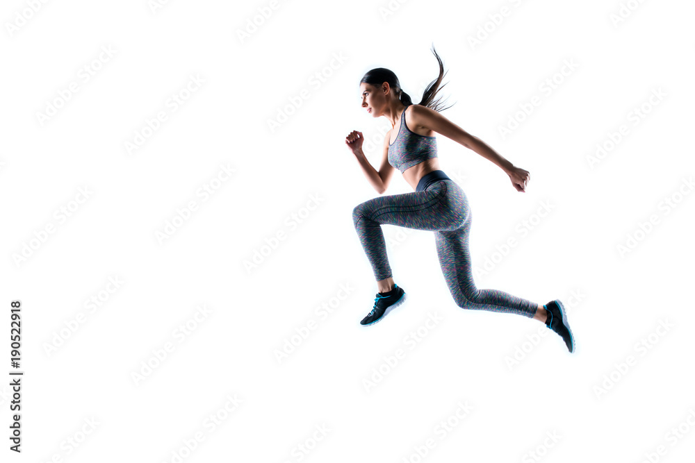 Dynamic movement. Full size side profile view portrait of strong sporty muscular beautiful running focused woman wearing tight sport clothing, isolated on white background, natural light, copy-space