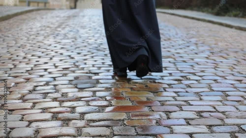 A woman is walking on the pavement. The girl is exploring a new city, dressed in shoes and a skirt. Close-up. A woman is walking on the pavement. The girl is exploring a new city, dressed in shoes and a skirt. Close-up.