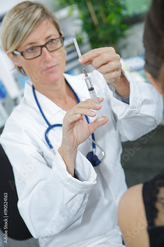 doctor prepares an injection for a patient