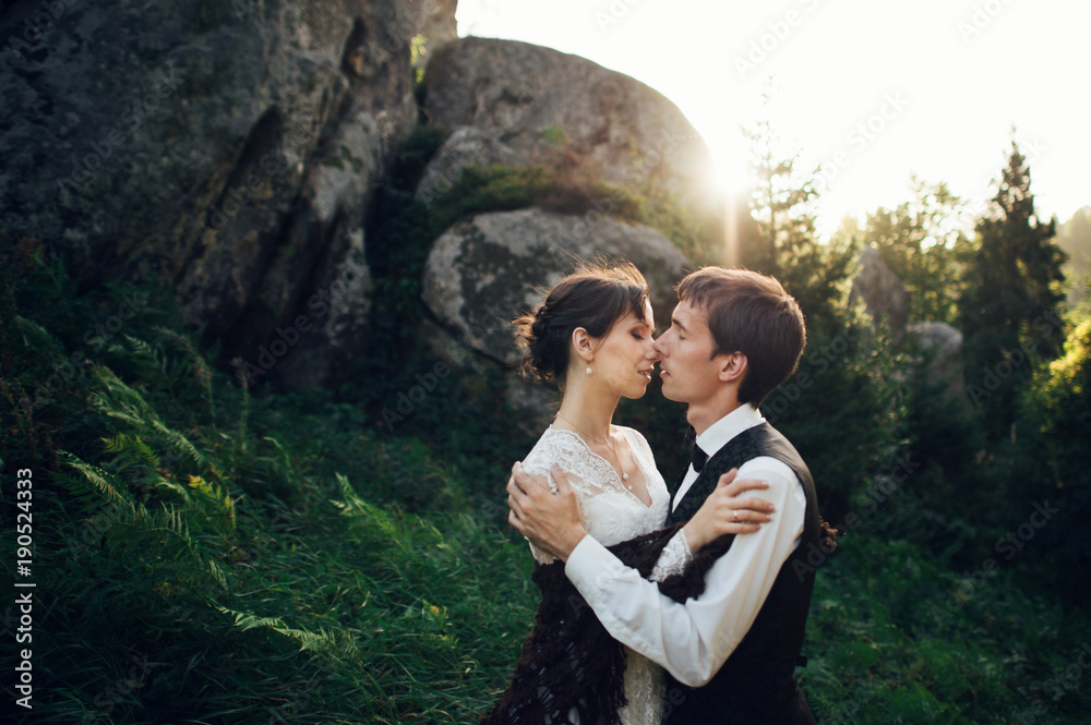 Amazing wedding couple is hugging each other in mountains Amazing wedding couple is hugging each other in mountains