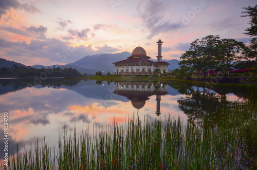 Beautiful sunrise and mirror reflection over majestic mosque.