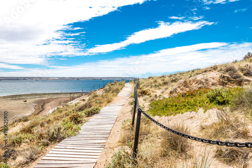 Bridge in Puerto Madryn beach, sun, waves and sand, beautiful day.