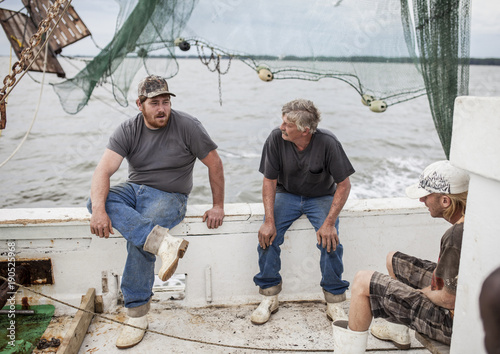 Fotografia, Obraz Environmental portrait of commercial fishermen on the deck of a ship