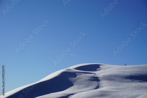 Schneehügellandschaft und blauer Himmel