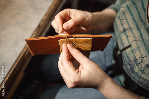 Close up of hands tanner performs work on table with tools photo