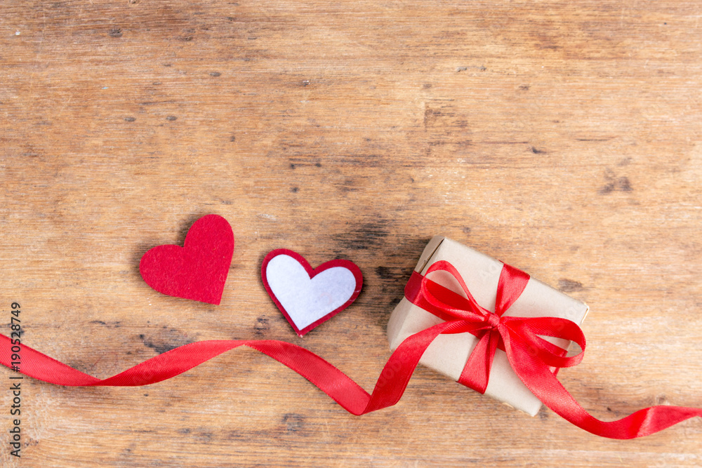 Valentine Gift Box and tiny red hearts on wooden table with copy space on top view. Happy Valentine Day concept. Valentine Gift Box and tiny red hearts on wooden table with copy space on top view. Happy Valentine Day concept.