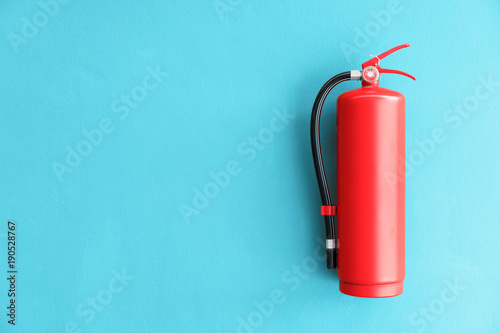 Fire extinguisher on the blue wall background. photo