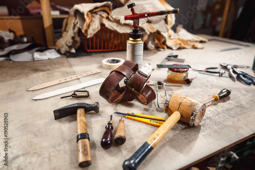 Close up of hands tanner performs work on table with tools photo