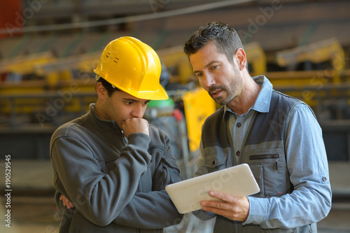 workers looking at digital tablet in warehouse