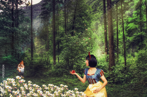 Snow White in a mysterious forest holds an apple in her hand. Artistic processing.
