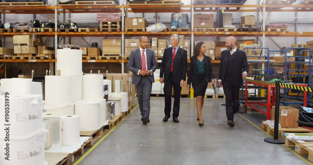 4K Business management team talking as they walk through warehouse. Slow motion. 4K Business management team talking as they walk through warehouse. Slow motion.