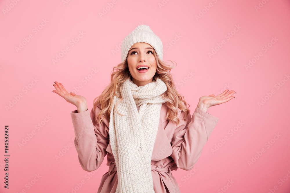 Happy young woman wearing warm scarf. Looking aside.